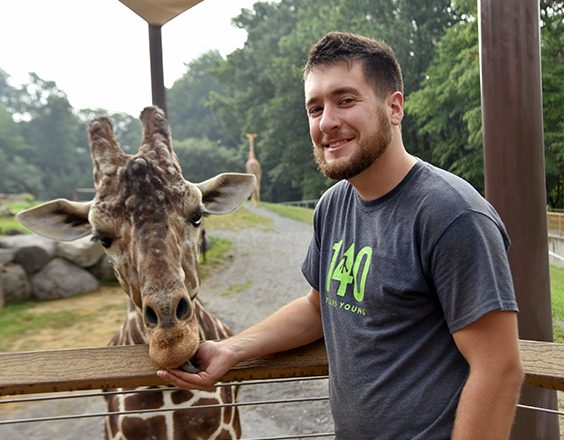 zoo keeper with giraffe