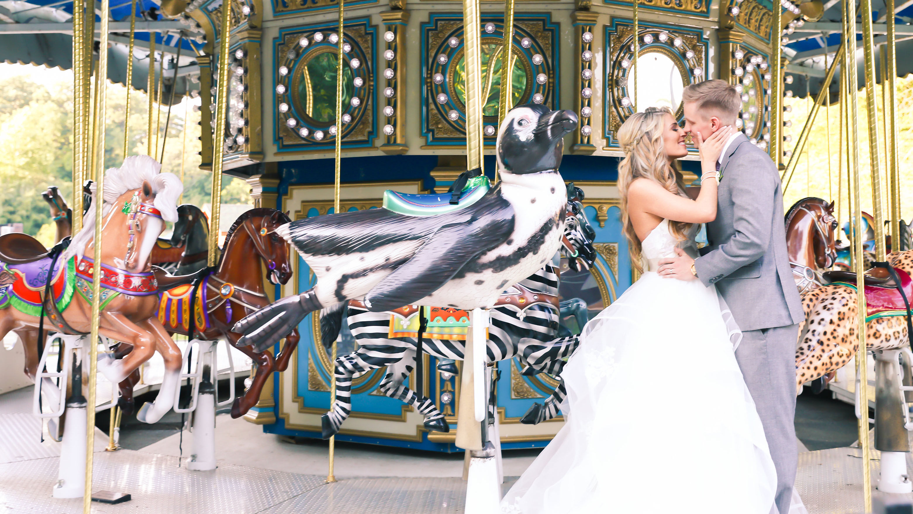 bride and groom kissing on carousel
