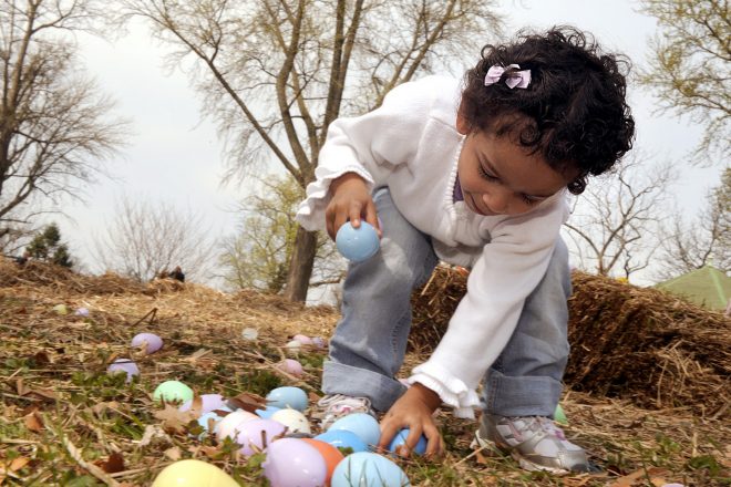 Child picking up egg