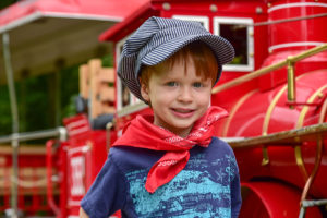 Child smiling in front of train