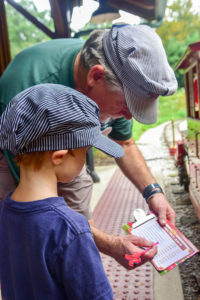 Man showing child train check list