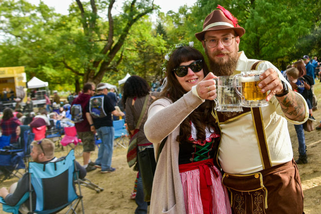 couple holding up beer mugs dressed in Oktoberfest garb