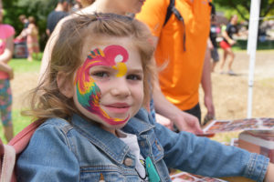 little girl with parrot face paint.