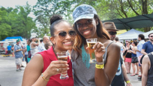 two women holding beer glasses at brew at the zoo event.