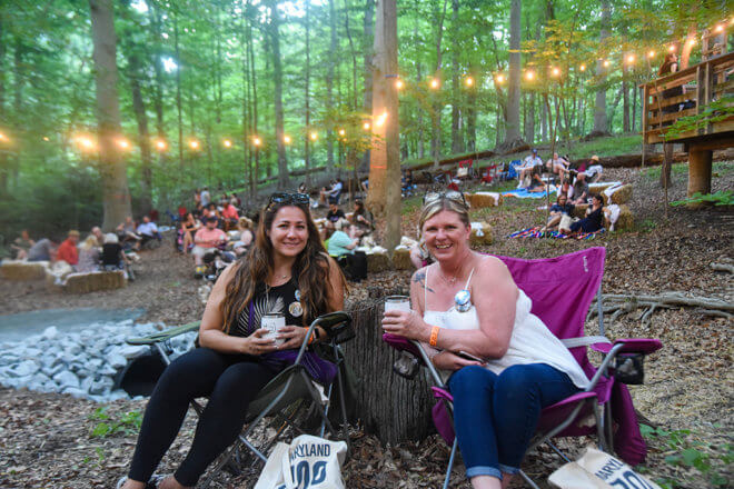 two women sitting in chairs in the woods