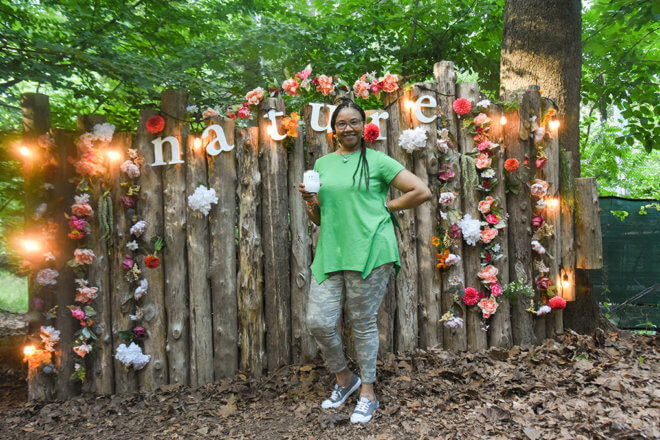 woman posing in front of flower backdrop