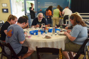 Guests at craft night, sitting around a table working on their crafts