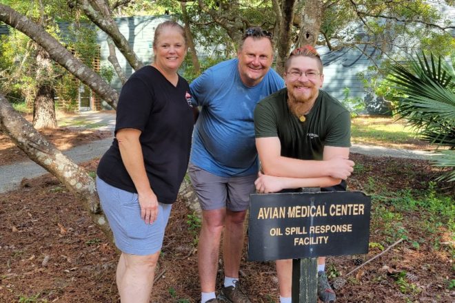 Zoo Staff Posing in front of a sign for an avian medical center