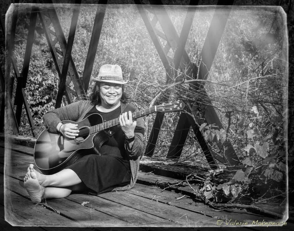 woman sitting playing a guitar