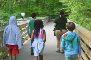 zoo educator leading kids down the boardwalk