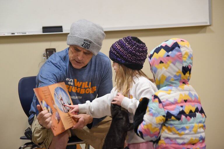 man reading a story to children