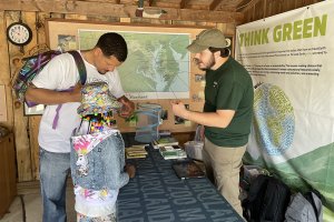 A zoo educator giving a presentation to a father and daughter at an education station.