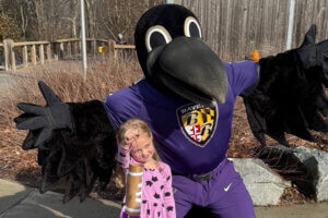 Baltimore Ravens mascot Poe with guest