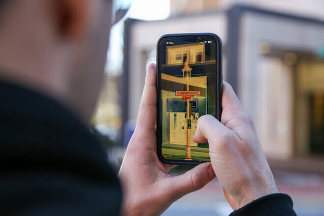 Man holding up phone and using the ReBokeh app to help read a sign